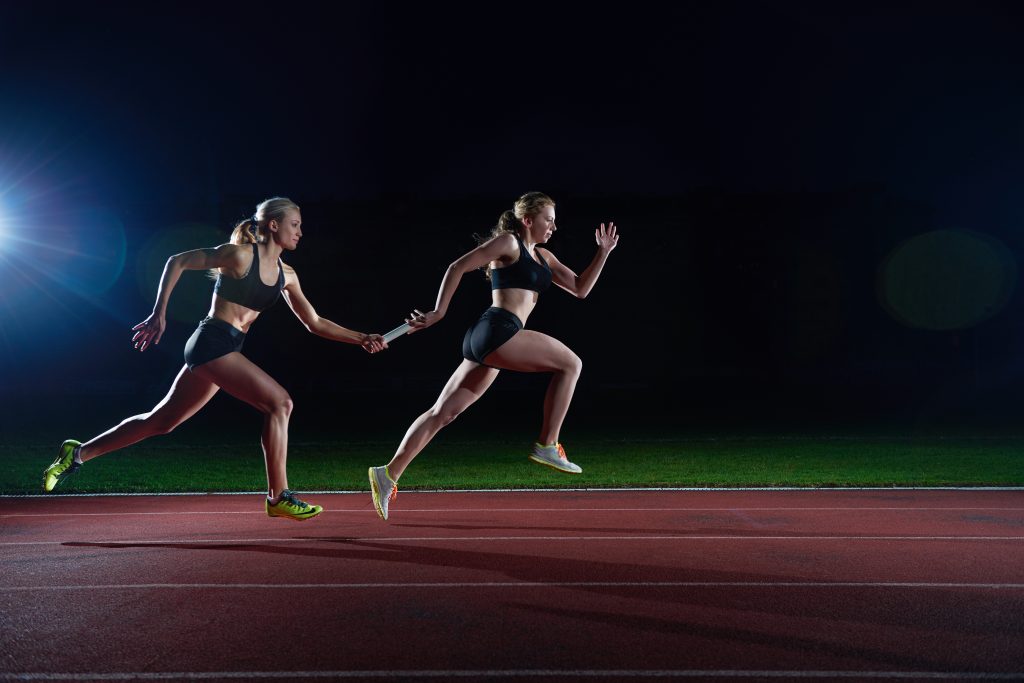 athletic runners passing baton in relay race Axialent
