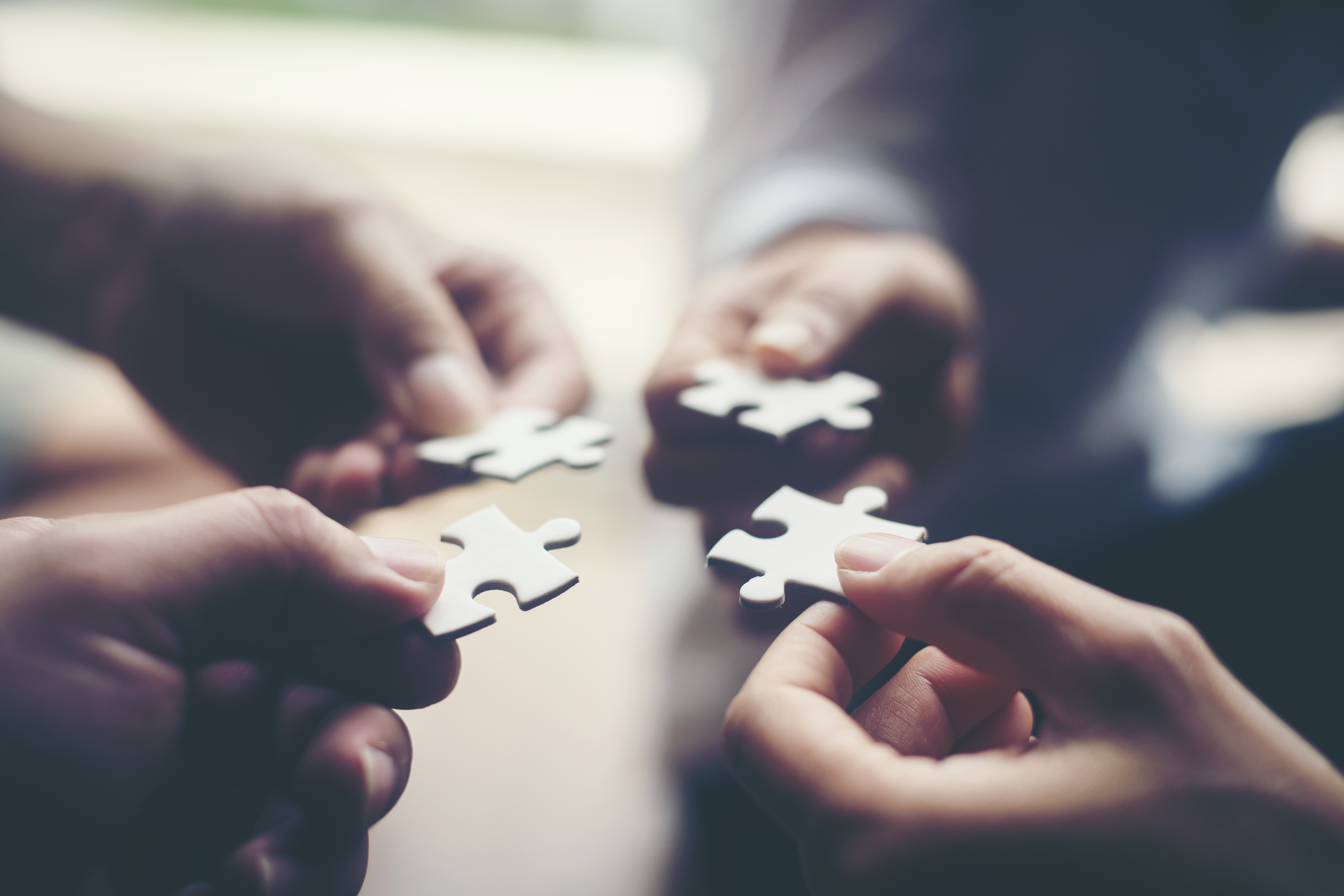 Scenario Planning 2.0 - Hands holding jigsaw puzzle pieces, Business partnership concept.